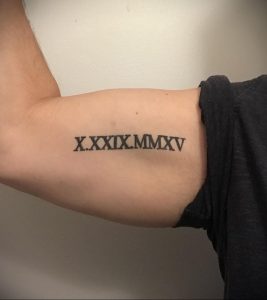 Фото тату: татуировка римскими цифрами 'X.XXIX.MMXV' на предплечье. Черный цвет, четкие линии, минималистичный дизайн.
