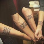 Фото парных татуировок с римскими цифрами на предплечьях. Черные цифры четко выделяются на светлой коже, символизируя важные даты для пары.