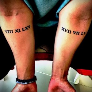 Фото тату: парные татуировки на предплечьях с римскими цифрами VIII XI LXV и XVII VII LV, выполненные черными чернилами.