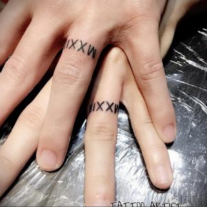 Фото тату: парные татуировки с римскими цифрами 'IXXW' и 'IXXW' на пальцах двух людей. Минималистичный дизайн, символизирующий связь и общую дату.