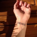 Фото тату: черные римские цифры 'VIII.VIIX' на запястье. Нежный и минималистичный дизайн, идеально подходит для девушек. Тонкие линии и аккуратное исполнение.