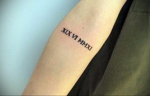 Фото тату: черные римские цифры 'XIX VI MMXI' на предплечье. Минималистичный дизайн, четкие линии, лаконичное исполнение. Идеально для любителей сдержанных татуировок.