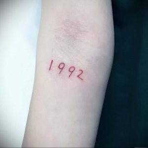 Фото тату на предплечье: красный год 1992, выполненный в минималистичном стиле. Простой и элегантный рисунок татуировки.
