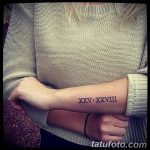Фото татуировки с римскими цифрами XXV.XXVIII на предплечье. Черно-белый рисунок, выполненный четкими линиями.