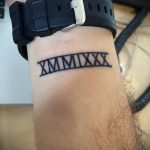 Фото тату: черные римские цифры 'XMMIXIX' на запястье. Минималистичный рисунок татуировки, выполненный четкими линиями. Идеально для тех, кто ищет идеи для тату.