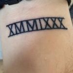Фото тату: черная татуировка римскими цифрами XMMIXXX на запястье мужчины. Строгий и лаконичный дизайн.