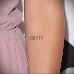 Фото тату: маленькая черная татуировка римскими цифрами VIII I IV на предплечье. Изящный и минималистичный дизайн.