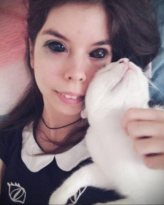 Фотография девушки, держащей на руках белого котенка. Нежный и милый образ, подчеркнутый светлой одеждой.