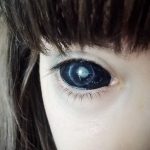 Крупный план глаза с голубым радужным цветом и темными ресницами. Выразительный взгляд и четкая детализация.
