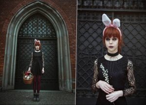 Фотография девушки с рыжими волосами в черном платье и с ушками зайчика. Девушка держит корзину с цветами.