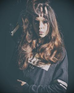 Фотография девушки с рогами, создающей демонический образ. Идеально для вдохновения на татуировки в стиле dark fantasy.