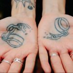 Фото тату: наручники на ладонях, выполненные в черно-белом стиле. Детализированный рисунок, минималистичный и символичный.