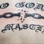 Фото тату на теле: надпись "No Gods No Masters" с изображением разорванных цепей. Символизирует анархию, свободу и независимость.