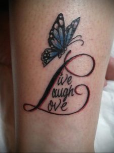 Фото татуировки на ноге с изображением синей бабочки и надписью 'Live Laugh Love'. Красные контуры, детализированный рисунок.