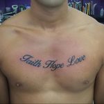 Фото татуировки с надписью 'Faith Hope Love' на груди мужчины. Темно-синий цвет, каллиграфический шрифт.