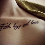 Фото тату на ключице: надпись "Faith, hope and love" изящным каллиграфическим шрифтом черными чернилами. Нежный и вдохновляющий дизайн.