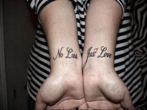 Фото парных татуировок на запястьях с надписями "No Lies Just Love". Черно-белые татуировки, выполненные простым шрифтом, символизирующие доверие и любовь.