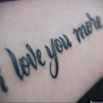 Фото тату надписи 'I Love You More' на руке. Черно-серая татуировка, выполненная каллиграфическим шрифтом, с акцентом на слове 'More'.