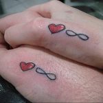 Фото парных татуировок с изображением сердца и символа бесконечности на руках. Нежные цвета и минималистичный дизайн.