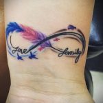 Фото тату с надписями 'Love' и 'Family', изображенными внутри символа бесконечности, с добавлением перьев и звезд.