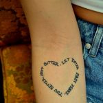 Фотография круговой татуировки на руке с надписью 'Bitter. Let your past make you better, not bitter'. Черный контур, минималистичный дизайн.