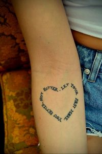 Фотография круговой татуировки на руке с надписью 'Bitter. Let your past make you better, not bitter'. Черный контур, минималистичный дизайн.