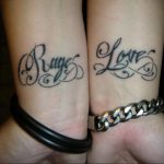 Фотография парных татуировок на запястьях с надписями 'Rage' и 'Love'. Татуировки выполнены черными линиями в каллиграфическом стиле.