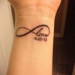 Фото тату на запястье: символ бесконечности с надписью 'love' и датой '9-25-13'. Черно-белый рисунок татуировки в минималистичном стиле.