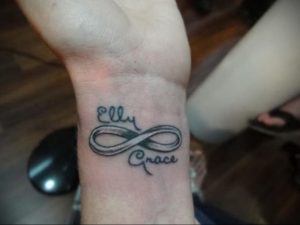 Фото парных татуировок на запястьях с именами 'Elly' и 'Grace', заключенными в символ бесконечности. Черно-белый рисунок татуировки.