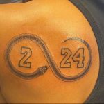 Фото тату с номерами '2' и '24' в круге на плече. Мужская татуировка, посвященная баскетболисту Кобе Брайанту.