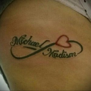 Фото тату бесконечности с именами 'Michael' и 'Madison' на плече. Зеленые и красные цвета, каллиграфический стиль, парная татуировка.