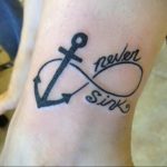 Фото тату бесконечности с изображением якоря и надписью 'never sink' на предплечье. Черно-белая татуировка, морская тематика.