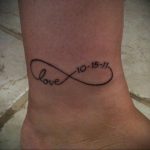 Фото тату бесконечности на лодыжке с надписью 'love' и датой '10-15-11'. Минималистичный дизайн, черные линии, женственная татуировка.
