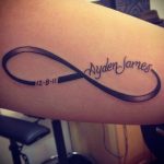 Фото тату бесконечность на предплечье с надписью 'Ayden James' и датой '12.8.11'. Черно-белый рисунок татуировки в минималистичном стиле.