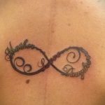 Фото тату бесконечность на спине, вписанные слова 'Mother' и 'Daughter' каллиграфическим шрифтом. Изящный рисунок татуировки для выражения семейной любви.