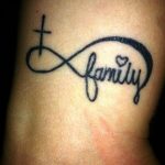 Фото тату на лодыжке: знак бесконечности с крестом и надписью 'Family'. Черно-серая татуировка, символ веры и любви к семье.