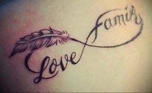 Фото тату бесконечности с пером и надписью 'family'. Черно-серый рисунок татуировки, символизирующий свободу и любовь к семье.