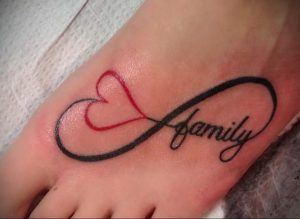 Фото тату бесконечности на стопе с красным сердцем и надписью 'family'. Черно-красный рисунок татуировки, символизирующий любовь к семье.