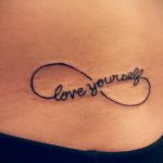 Фото тату: минималистичная татуировка бесконечности на боку с надписью 'love yourself', выполненная тонкими черными линиями.