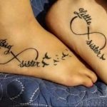 Фото парных тату бесконечность с летящими птицами и надписями 'Big Sister' и 'Little Sister' на стопах.