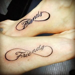 Фото двух стоп с татуировками бесконечности, внутри которых написана надпись 'Friends'. Черно-белый рисунок.