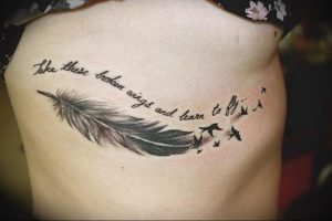 Фото тату на боку: перо, летящие птицы и надпись 'Take these broken wings and learn to fly'. Черно-белый рисунок с глубоким смыслом.