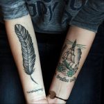 Фото парных татуировок на предплечьях: одно изображение пера, другое - корабля и маяка. Черно-белые рисунки.