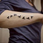 Фото тату: минималистичный рисунок летящих птиц на предплечье, выполненный в черном цвете. Идеально для любителей простых и символичных татуировок.
