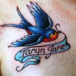 Фото тату: ласточка в стиле олд скул с надписью 'Taryn Jane' на ленте. Яркие цвета, четкие контуры, традиционный стиль.