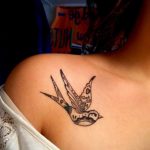 Фото тату ласточки на плече, выполненной в технике blackwork с использованием геометрических узоров и точечной штриховки.