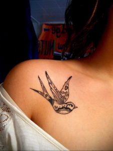 Фото тату ласточки на плече, выполненной в технике blackwork с использованием геометрических узоров и точечной штриховки.