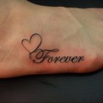 Фото тату: небольшое сердце с надписью 'Forever' на женской стопе. Минималистичный и романтичный дизайн.