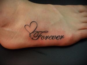 Фото тату: небольшое сердце с надписью 'Forever' на женской стопе. Минималистичный и романтичный дизайн.