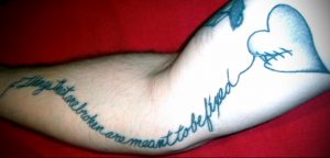 Фото тату разбитого сердца с надписью 'Things that are broken are meant to be fixed' на руке. Эмоциональный рисунок татуировки.